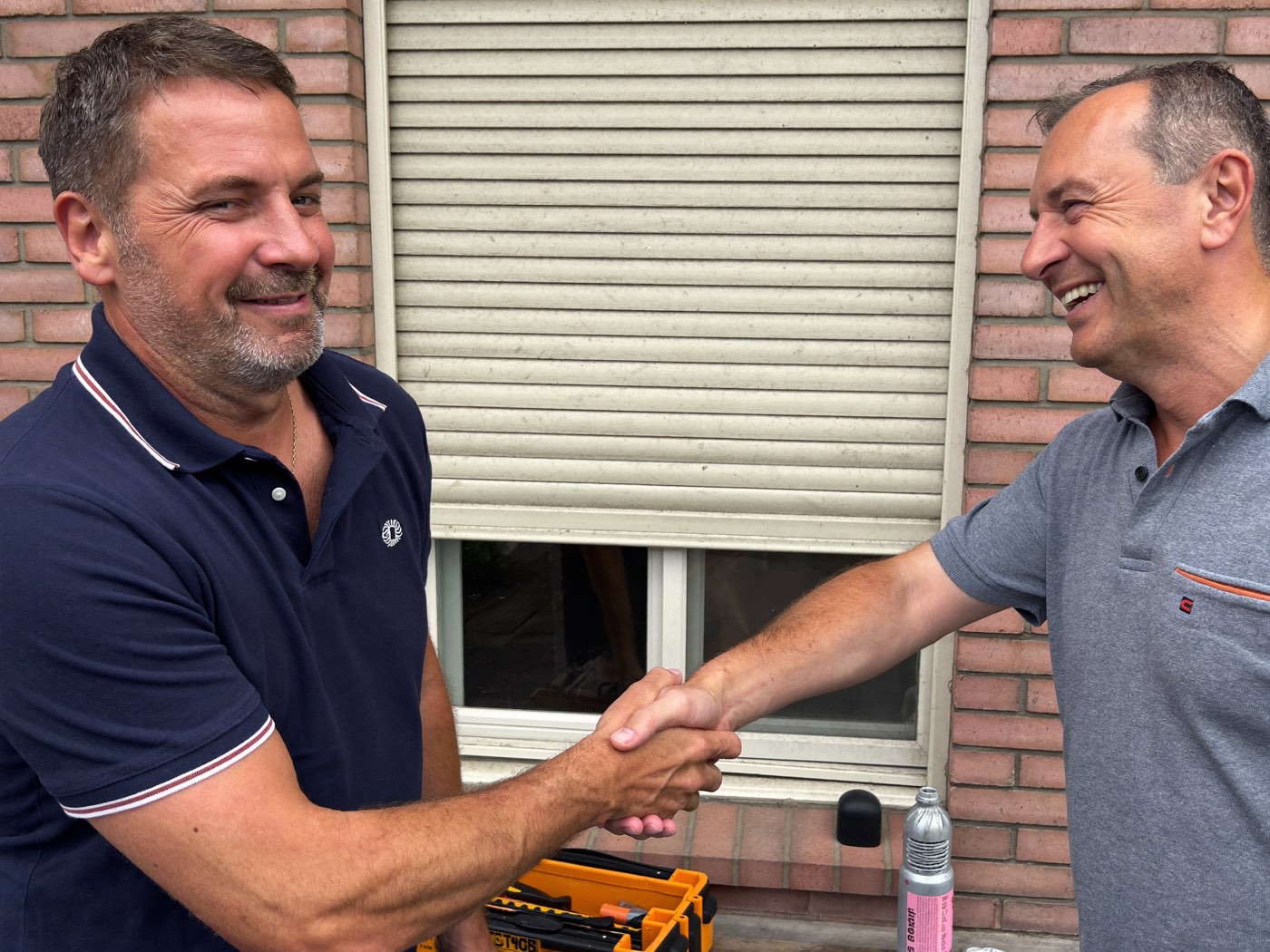 Artisan Midi Volets et client se serrant la main après une réparation